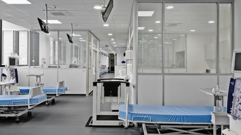 Interiér dialyzačního střediska s několika prázdnými lůžky