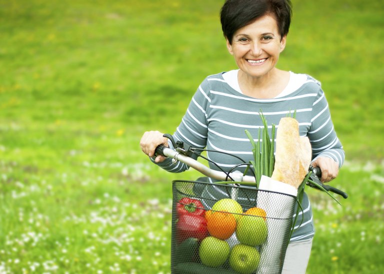 [Translate to Czechia - Czech:] Woman on a bike with healthy food in the basket